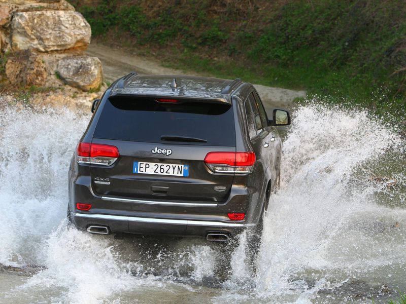 2013 grey jeep grand cherokee summit driving though a river at speed