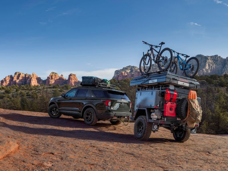 green 2021 Ford Explorer Timberline with adventure trailer and bicycles at tow