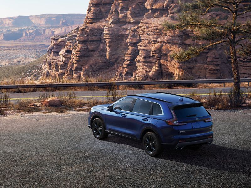 blue honda crv hybrid next to a cliff