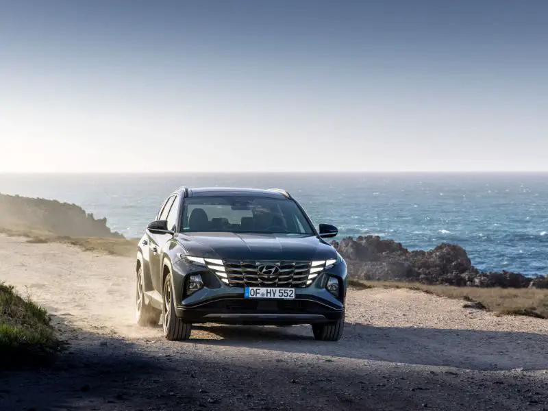hyundai tucson driving next to the ocean on a gravel road