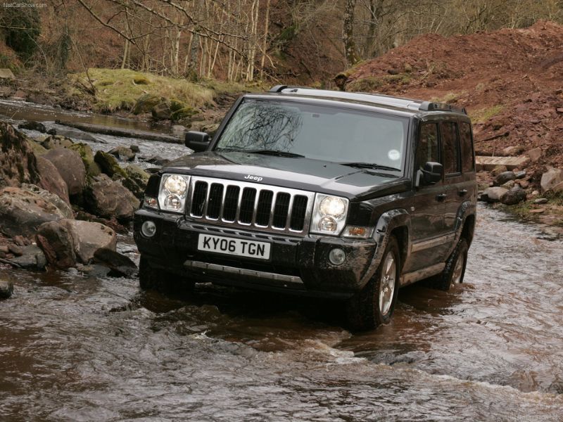 2007 black jeep commander crd limited driving though a creek in the woods