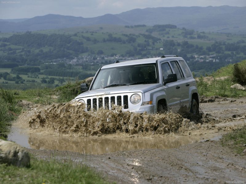 2007 silver jeep patriot crd limited driving through a deep mud bog