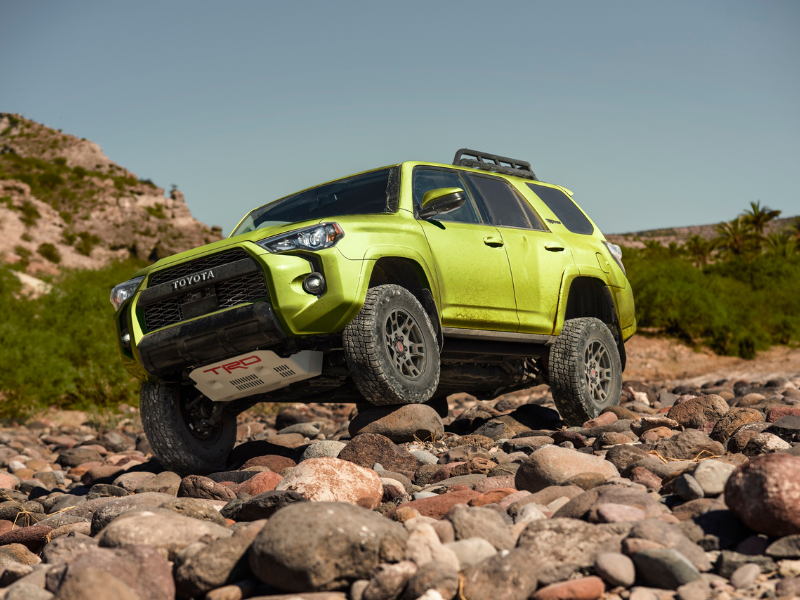 2022 lime green toyota 4runner trd pro lime rush driving through a rocky river bed