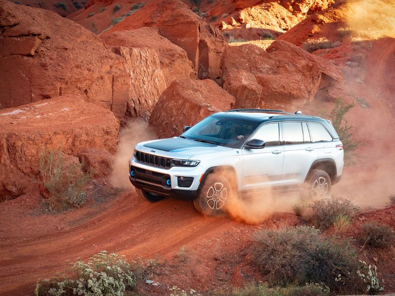 2022 white jeep grand cherokee trailhawk 4xe driving over dirt mounds in utah