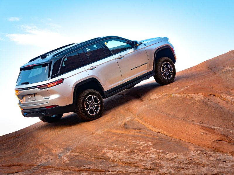 2023 silver jeep grand cherokee 4xe plug in hybrid climbing a hill in moab