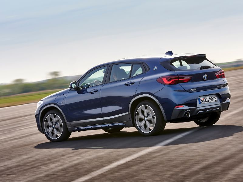 2020 blue bmw x2 hybrid driving on a closed circuit
